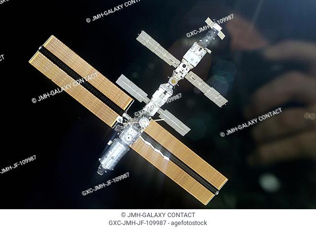 The International Space Station (ISS) backdropped against black space was photographed with a digital still camera from the Space Shuttle Discovery on March 18
