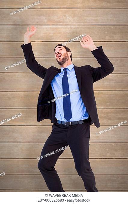 Composite image of shocked businessman standing and pushing up
