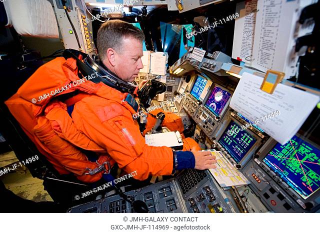 Attired in a training version of his shuttle launch and entry suit, NASA astronaut Steven Lindsey, STS-133 commander, occupies the commander's station during a...