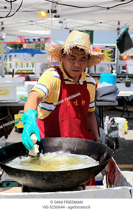 CANADA, MARKHAM, 13.07.2013, A Chinese cook drops cubes of tofu into a wok filled with boiling oil while preparing Hong Kong style 'stinky' tofu at a Chinese...