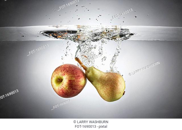Close-up of apple and fruit in splashing water