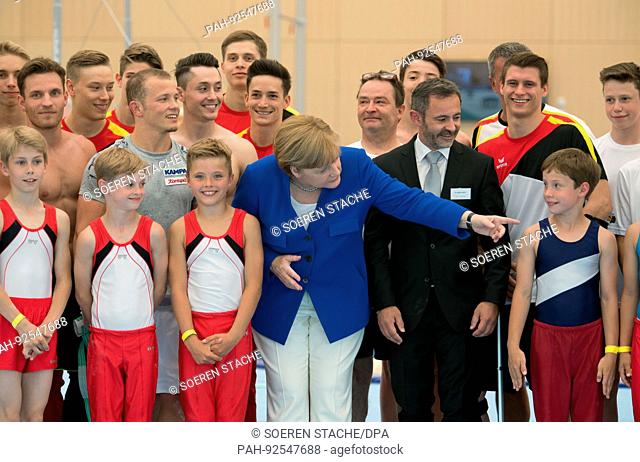 dpatop - German Chancellor Angela Merkel (CDU), Alfons Hoelzl, President of the German Athletic Association (DTB) and athletes gather for a group photo in a...