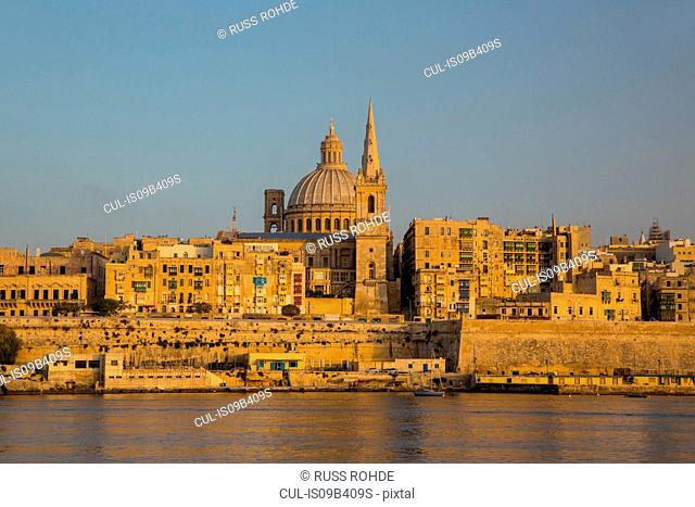 Dome of carmelite church and St. Paul's Cathedral over water, Valletta, Malta