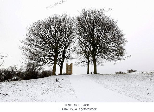 Broadway Tower framed by bare trees in snow, Broadway, Cotswolds, Worcestershire, England, United Kingdom, Europe