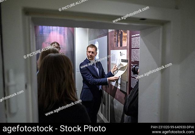 20 October 2023, Saxony, Chemnitz: Michael Kretschmer (CDU), Minister President of Saxony, learns about the life of a contemporary witness who was imprisoned...