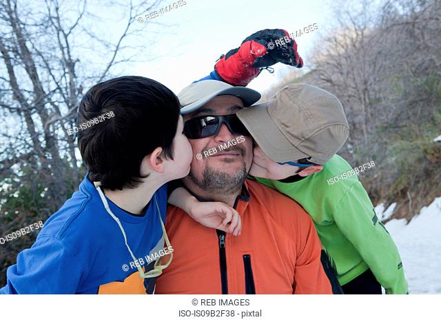Man taking selfie with twin sons kissing his cheek in Andes, Valparaiso, Chile