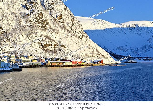 Harbour with quay wall and warehouses from the small village Øksfjord surrounded by snow-white mountains, 9 March 2017 | usage worldwide