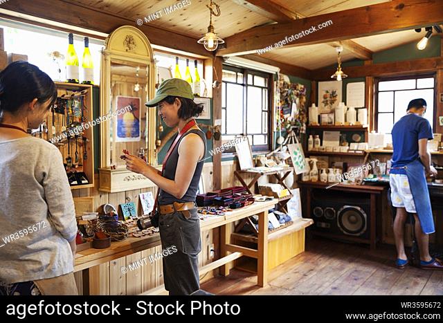Two Japanese women and man standing in a leather shop