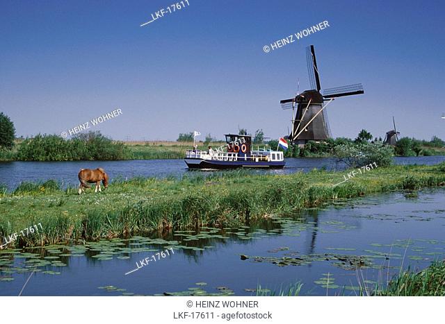 Windmill at a riverbank, Kinderdijk, Netherlands, Europe