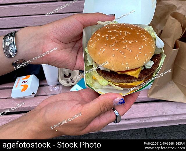 12 June 2022, Russia, Moskau: A man holds a burger from the Russian McDonald's successor in Moscow. Photo: Hannah Wagner/dpa. - Moskau/Russia