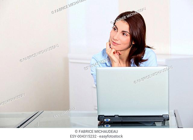 Portrait of businesswoman in front of laptop computer