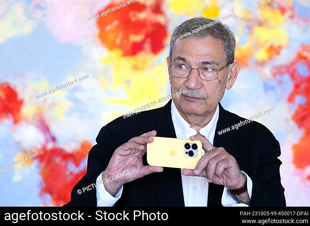 05 October 2023, Saxony, Dresden: Orhan Pamuk, Turkish winner of the Nobel Prize for Literature, holds his smartphone on the sidelines of a press conference for...