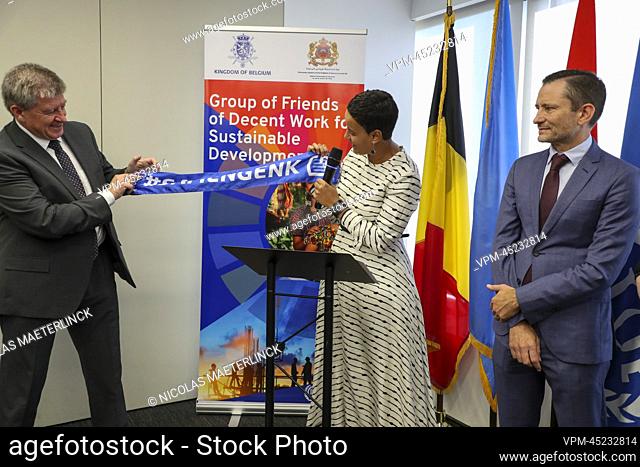 outgoing ILO director-general Guy Rider (L) receives a scarf of Belgian soccer team KRC Genk from Minister for Development Cooperation Meryame Kitir (C) during...