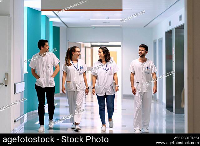 Doctors discussing while walking in corridor at hospital