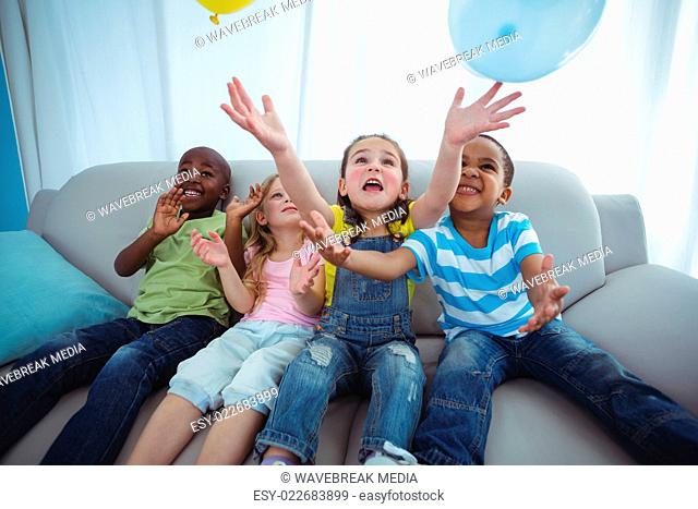 Smiling kids playing with balloons
