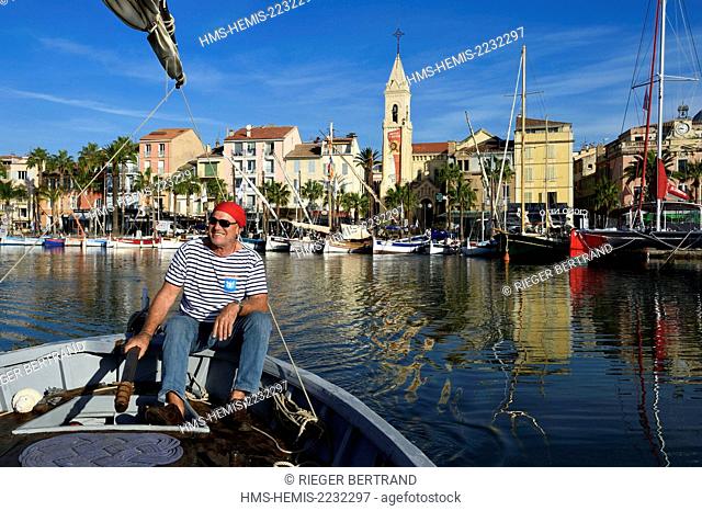 France, Var, Sanary-sur-Mer, traditional fishing boats called pointus in the port and St. Nazaire Church, Christian Benet who is president of the Sanary Pointus...