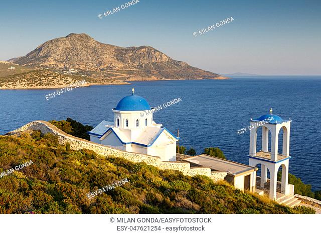 Church in the town of Fourni and view of Thymaina island early in the morning, Greece.