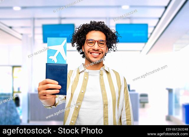 happy man with passport and air ticket at airport