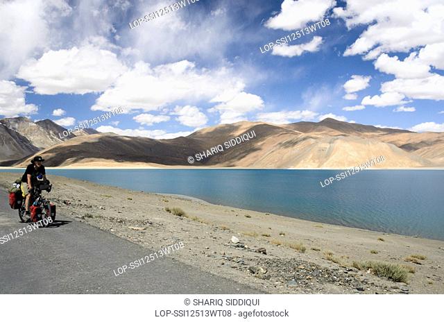 India, Jammu and Kashmir, Pangong Lake. A European man cycles along Pangong Tso