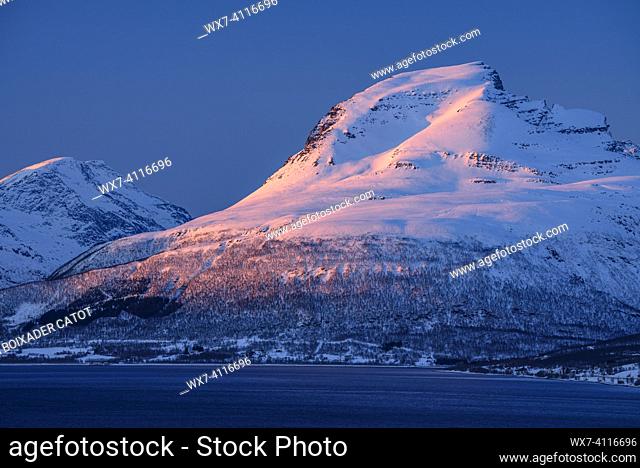 Sunset over the mountains of the Balsfjorden fjord near Tromsø on a sunny winter afternoon (Tromsø, Norway)