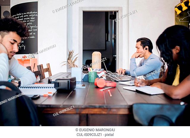 Young businessmen and woman remote working at cafe table