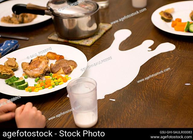 Cup of Spilled Milk on Dinner Table