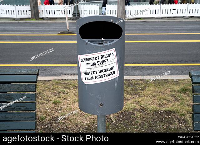 Berlin, Germany, Europe - A sticker with the lettering Disconnect Russia from Swift - Protect Ukraine from airstrikes is stuck to a dustbin in between two...
