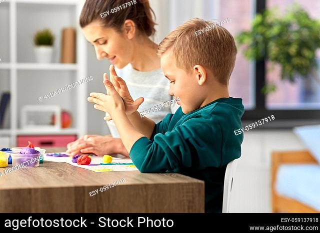 mother and son playing with modeling clay at home