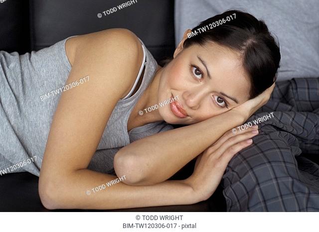 Portrait of Hispanic woman laying on boyfriendÆs leg