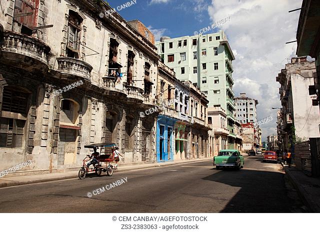 American cars and a bici-taxi on the road near Vedado, Havana, Cuba, West Indies, Central America