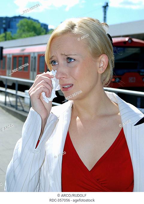 Young woman at rail station, train track