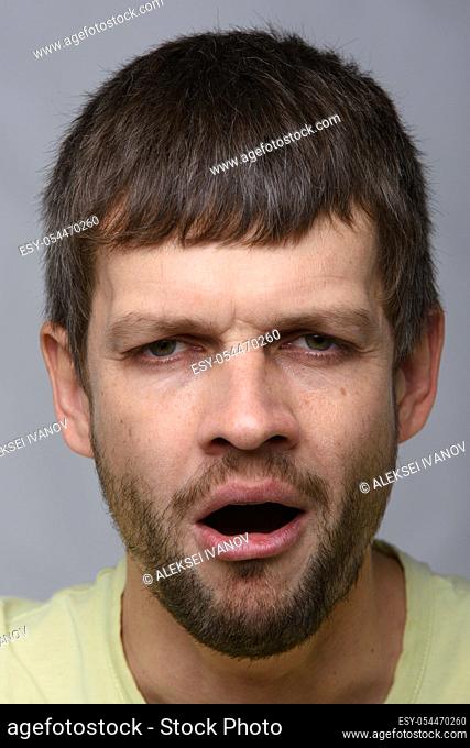 Closeup portrait of a tired yawning man of European appearance