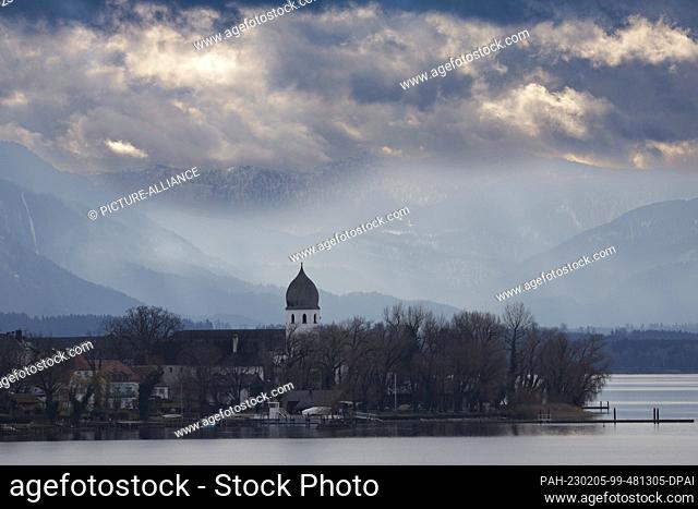 05 February 2023, Bavaria, Chiemsee: The bell tower of the Frauenchiemsee monastery complex on Fraueninsel in Lake Chiemsee shows off against the backdrop of...