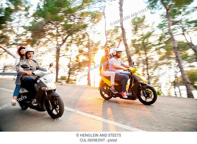 Two couples riding mopeds along coastal road, Split, Dalmatia, Croatia