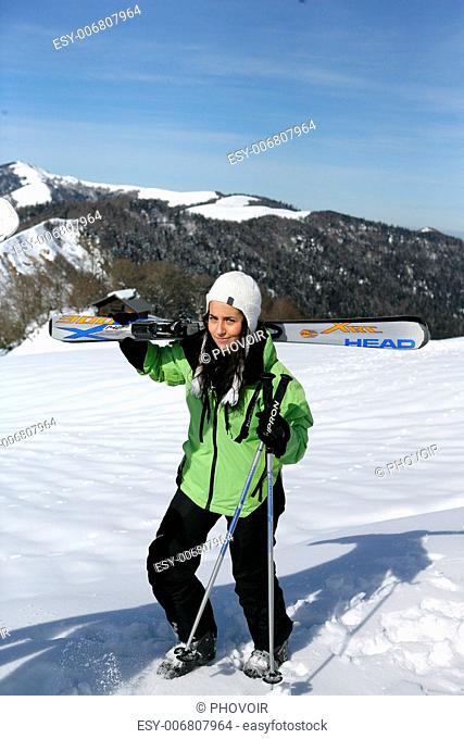 Young woman carrying her skis