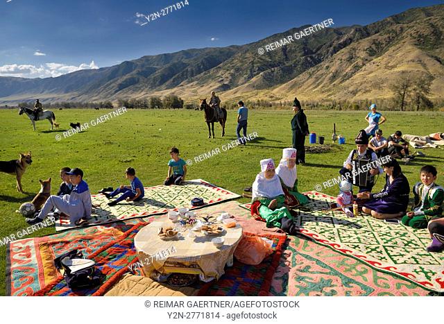 Saty townsfolk gathered for a picnic in pasture by the Chilik river and Kungey Alatau mountains Kazakhstan