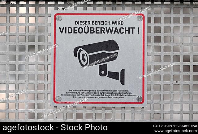 PRODUCTION - 08 December 2023, Thuringia, Erfurt: A sign draws attention to video surveillance on a private property. According to the Thuringian State...