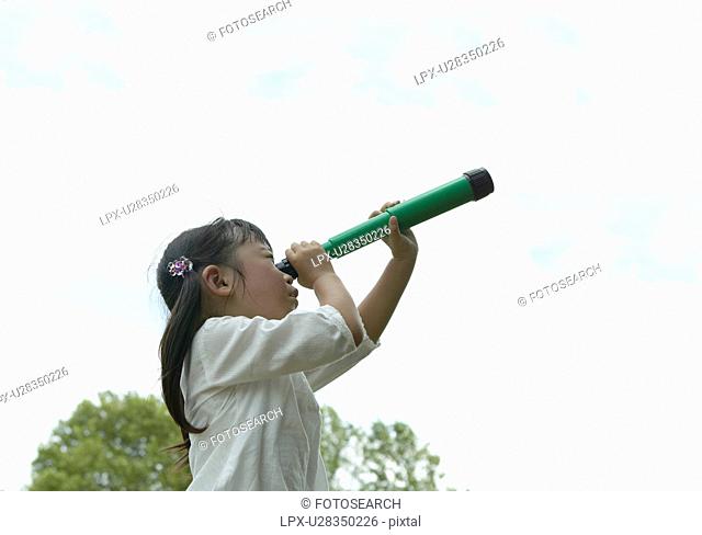 A girl looking into a Telescope