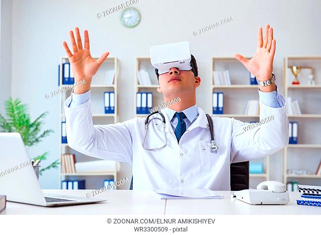 Young doctor with vr virtual reality headset working in the office