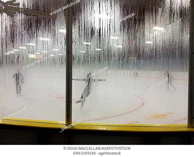 Figure skaters viewed through fogged glass practice at a community rink in Windsor, Ontario, Canada