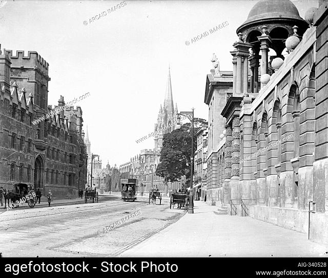 High Street, Oxford, Oxfordshire. General view looking west along the High Street with the entrance to Queens College in the foreground and St Mary's church...