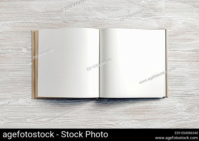 Opened blank square booklet on light wood table background. Flat lay