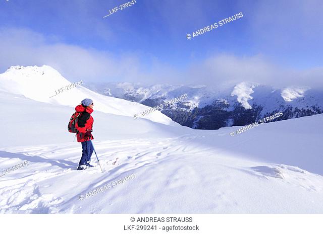 Woman back country skiing enjoying the view towards the Kitzbuehel mountain range, Schusterkogel, Saalbach-Hinterglemm, Kitzbuehel range, Salzburg, Austria