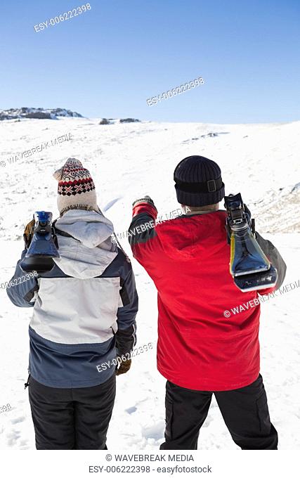 Rear view of a couple with ski boards on snow