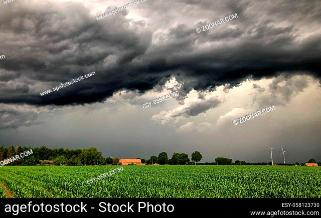 Threatening dark rainy clouds are covering a rural landscape, showing the Overcast and gloomy sky above the countryside creating a beautiful and impressive...