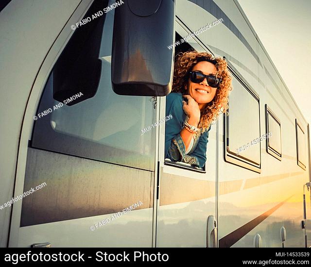 Traveler cheerful and happy expression beautiful young woman outside the driver window of modern camper van mothr home vehicle