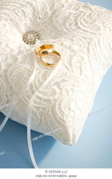 Studio shot of wedding rings on white pillow