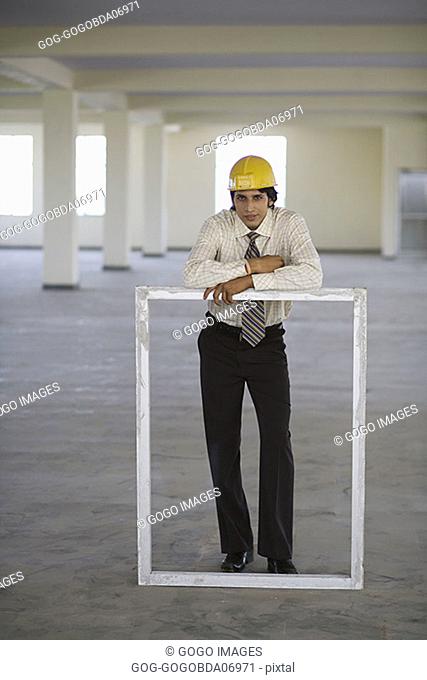 Businessman leaning on empty frame