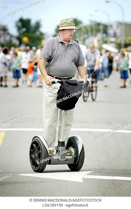 Senior male rides Segway balance two-wheel cart