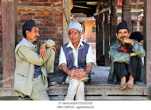 3 men in the Nepali traditional style were sitting calmly at Hanuman Dhoka Durbar world heritage monument zone, Kathmandu, Nepal